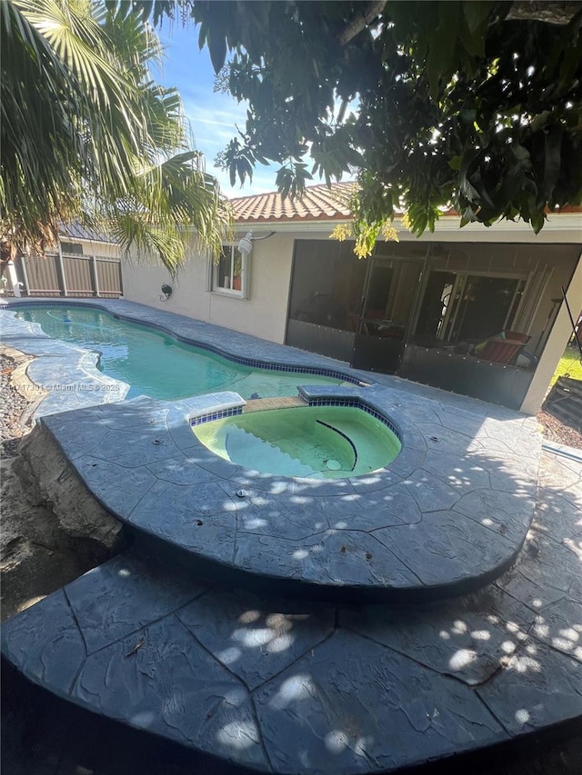 view of pool featuring an in ground hot tub