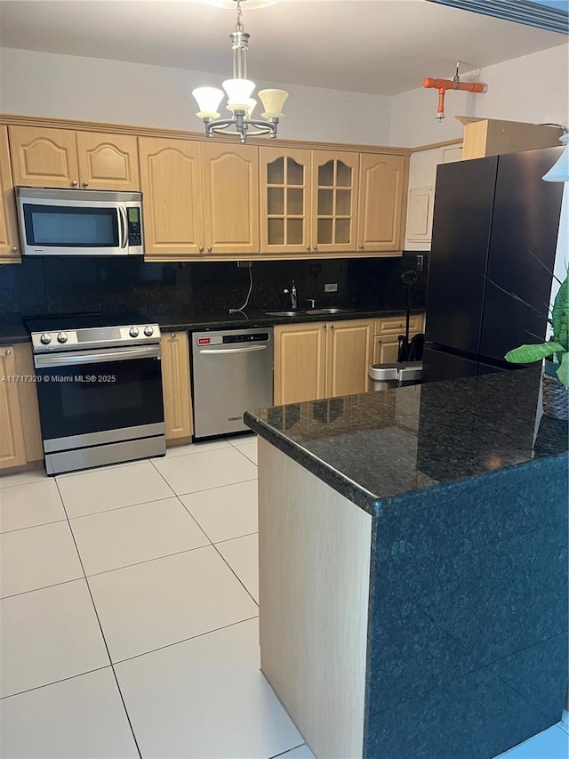 kitchen with appliances with stainless steel finishes, light brown cabinetry, sink, a notable chandelier, and hanging light fixtures