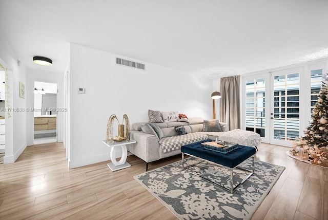 living room featuring french doors and light hardwood / wood-style floors