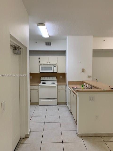 kitchen featuring light tile patterned flooring and white appliances