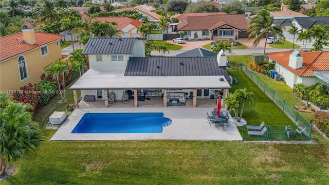 back of property with a patio, a fenced in pool, cooling unit, and a lawn