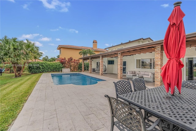 view of pool with a lawn, outdoor lounge area, and a patio