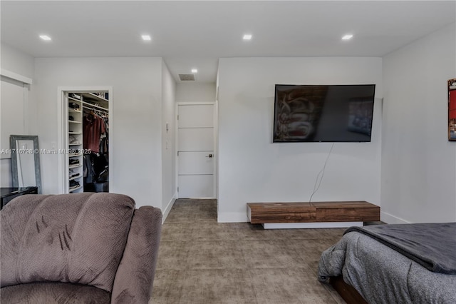 carpeted bedroom with a walk in closet and a closet