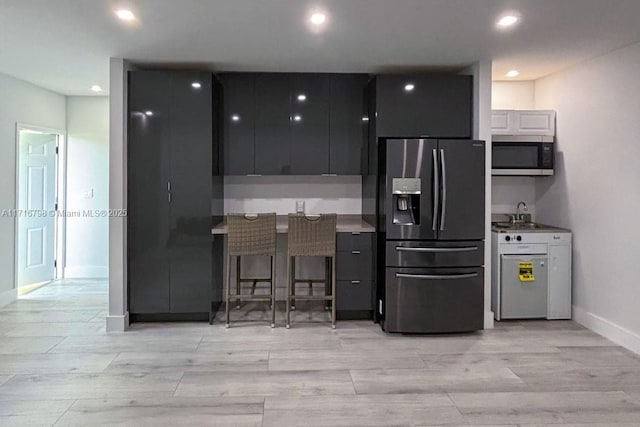 kitchen with a breakfast bar, stainless steel appliances, and sink