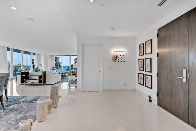 hallway featuring expansive windows and light tile patterned flooring