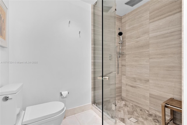 bathroom featuring tile patterned floors, a shower with door, and toilet