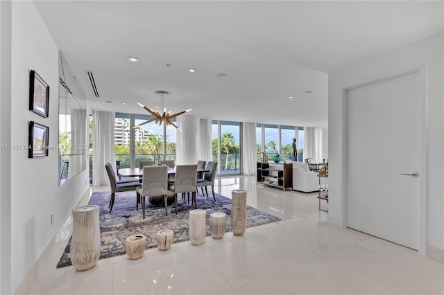 tiled dining area featuring a wealth of natural light, a chandelier, and a wall of windows