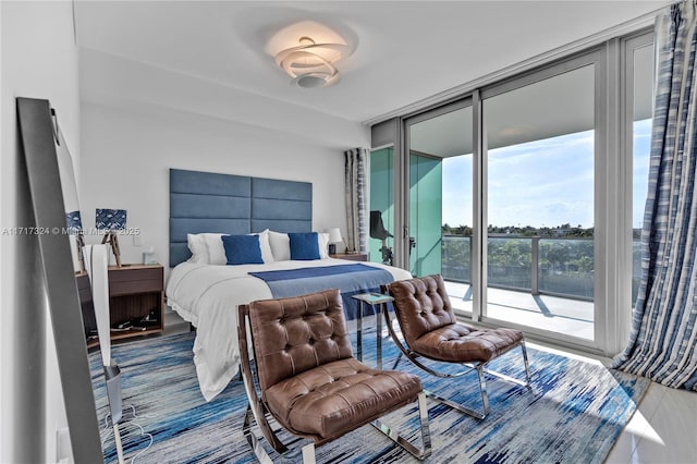 bedroom with a wall of windows and access to outside