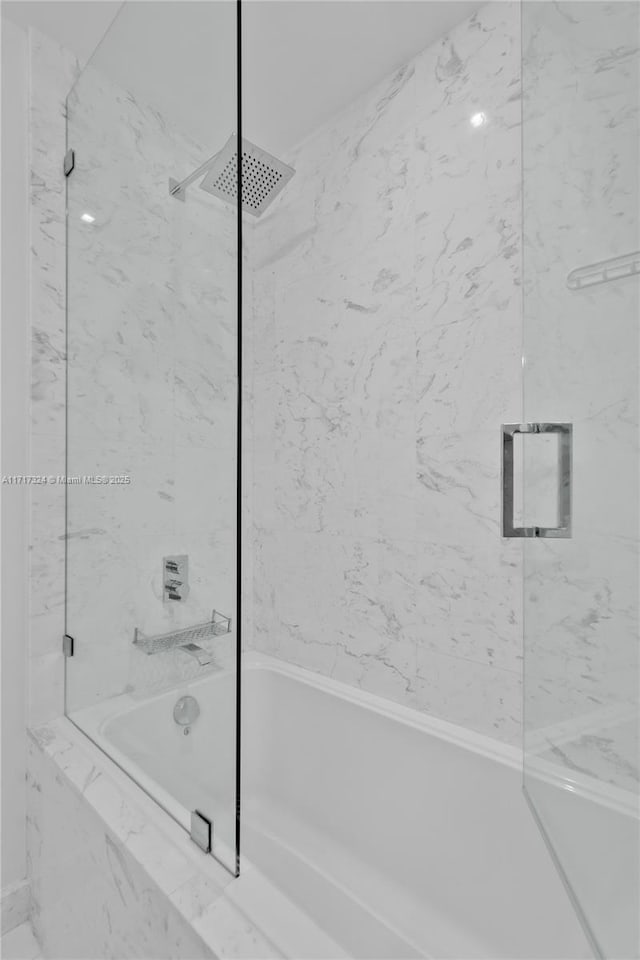 bathroom featuring combined bath / shower with glass door