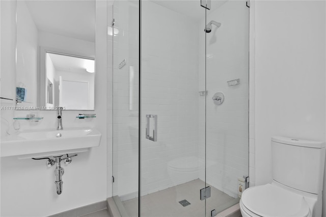 bathroom featuring toilet, walk in shower, and sink