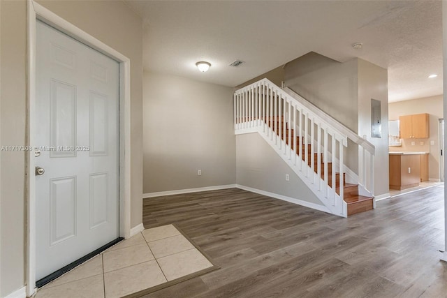 foyer entrance featuring a textured ceiling and hardwood / wood-style flooring