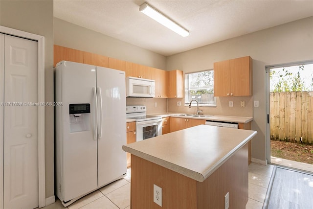 kitchen featuring a center island, sink, tasteful backsplash, white appliances, and light tile patterned flooring