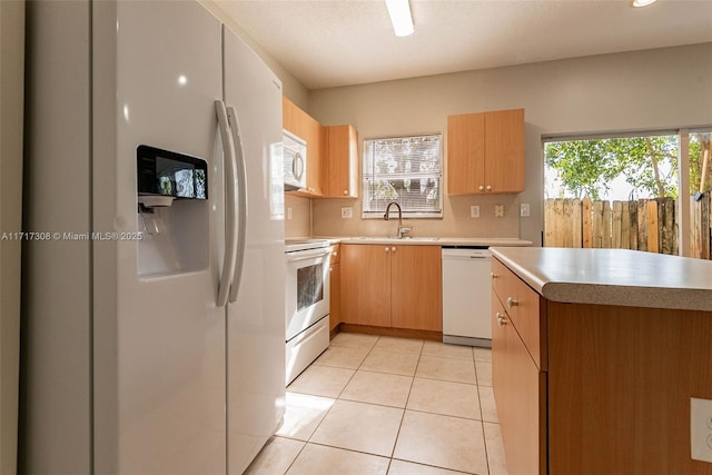 kitchen featuring decorative backsplash, white appliances, sink, and light tile patterned floors