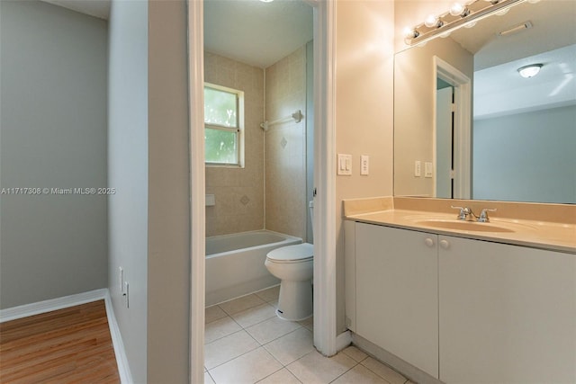 full bathroom featuring tile patterned flooring, tiled shower / bath combo, toilet, and vanity