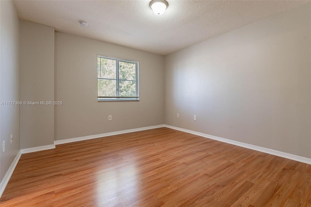 unfurnished room with light hardwood / wood-style floors and a textured ceiling