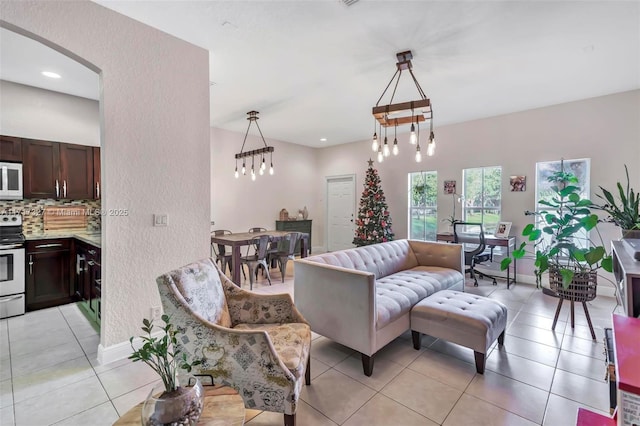 tiled living room featuring a notable chandelier