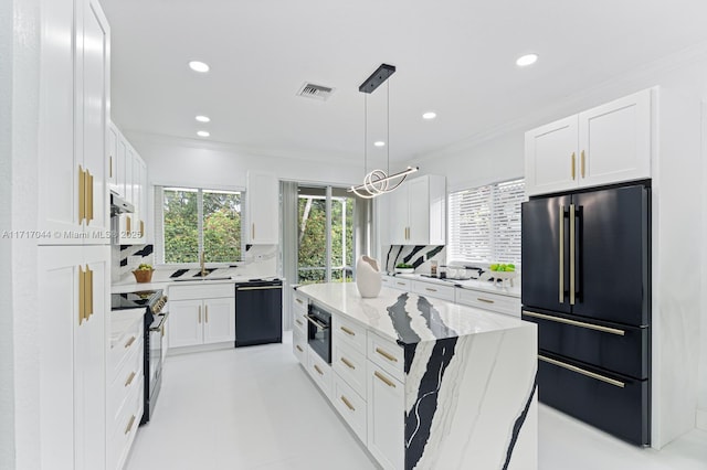 kitchen featuring light stone counters, black appliances, pendant lighting, white cabinets, and a center island