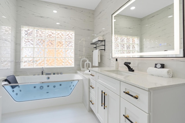 bathroom with plenty of natural light, vanity, and a bath