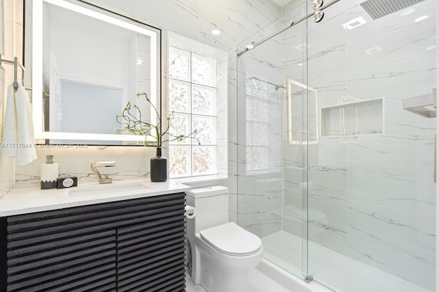 bathroom featuring plenty of natural light, toilet, a shower with door, and vanity