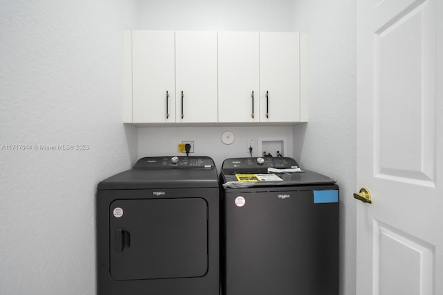 clothes washing area featuring cabinets and separate washer and dryer