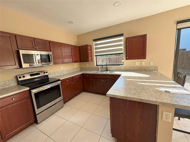 kitchen with kitchen peninsula, a breakfast bar, stainless steel appliances, and sink