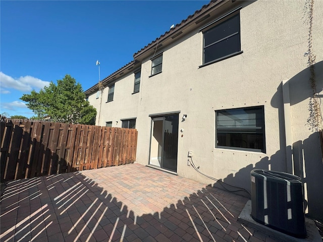 rear view of house featuring cooling unit and a patio