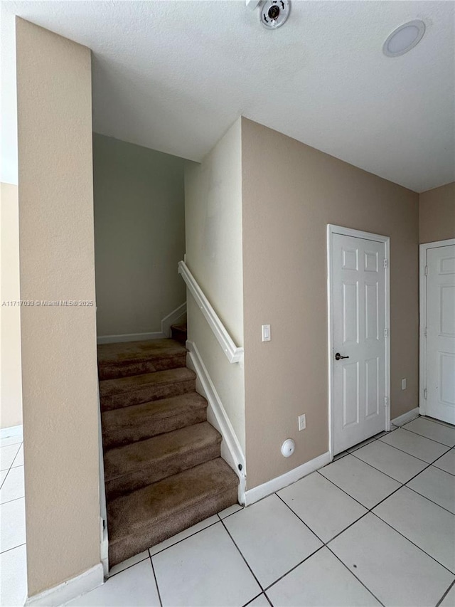 staircase featuring tile patterned floors