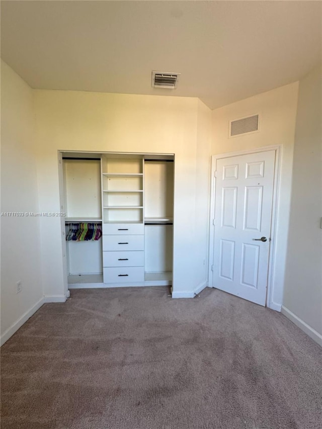 unfurnished bedroom featuring carpet flooring and a closet