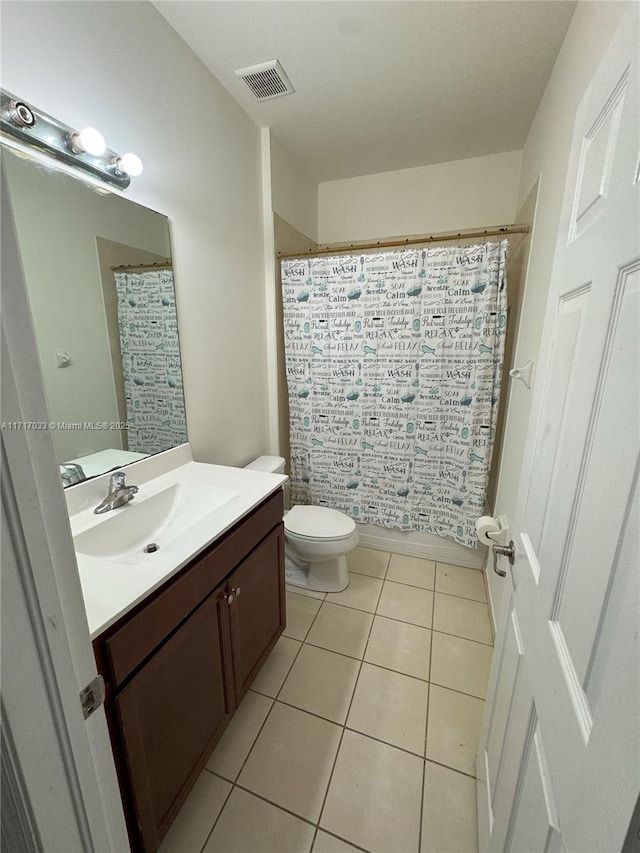 bathroom with tile patterned floors, walk in shower, vanity, and toilet