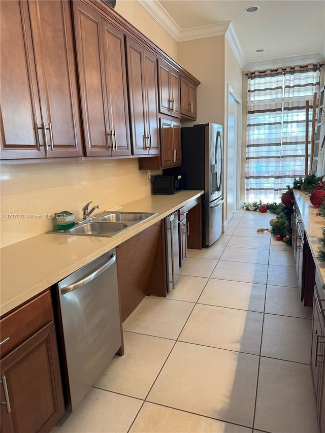 kitchen with crown molding, light tile patterned floors, sink, and appliances with stainless steel finishes