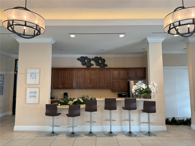 kitchen with a breakfast bar, an inviting chandelier, crown molding, light tile patterned floors, and stainless steel refrigerator