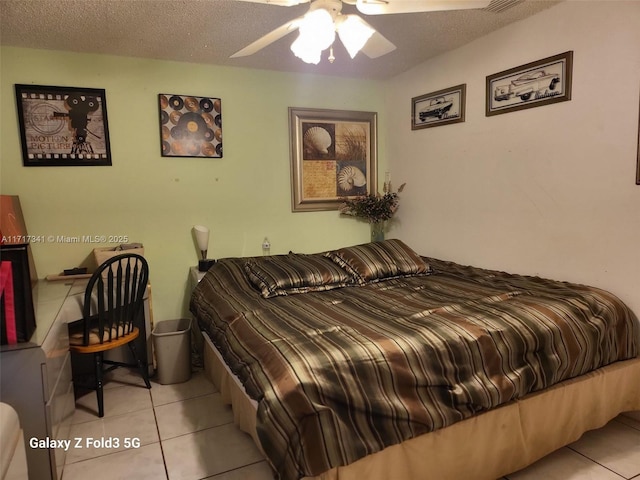 tiled bedroom featuring ceiling fan and a textured ceiling