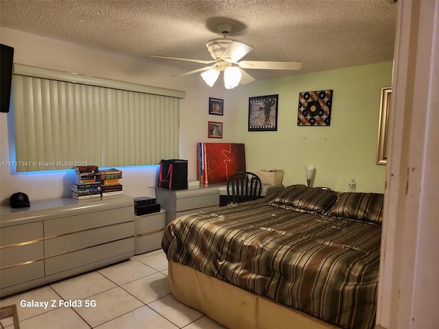 bedroom featuring light tile patterned flooring, ceiling fan, and a textured ceiling