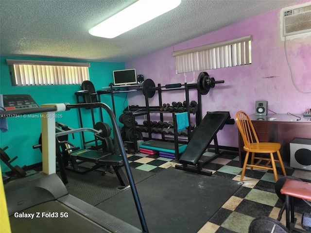 exercise room with a wall mounted AC and a textured ceiling