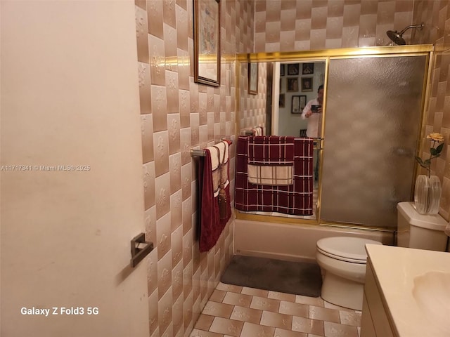 full bathroom with toilet, vanity, and shower / bath combination with glass door