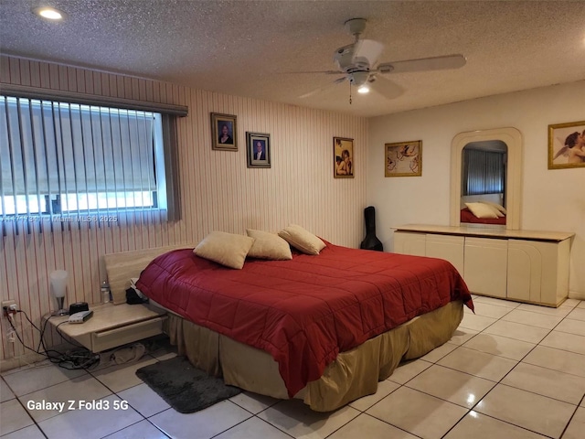 bedroom featuring ceiling fan, a textured ceiling, and light tile patterned flooring