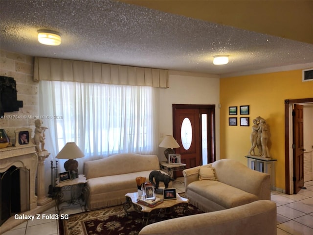 tiled living room featuring a fireplace and a textured ceiling