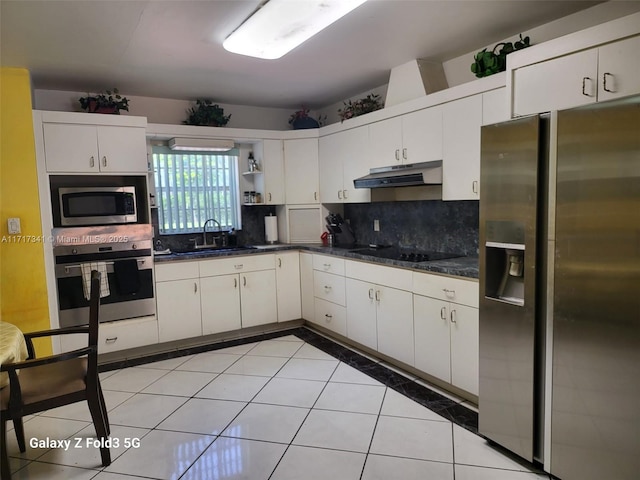 kitchen featuring sink, white cabinetry, backsplash, stainless steel appliances, and light tile patterned flooring