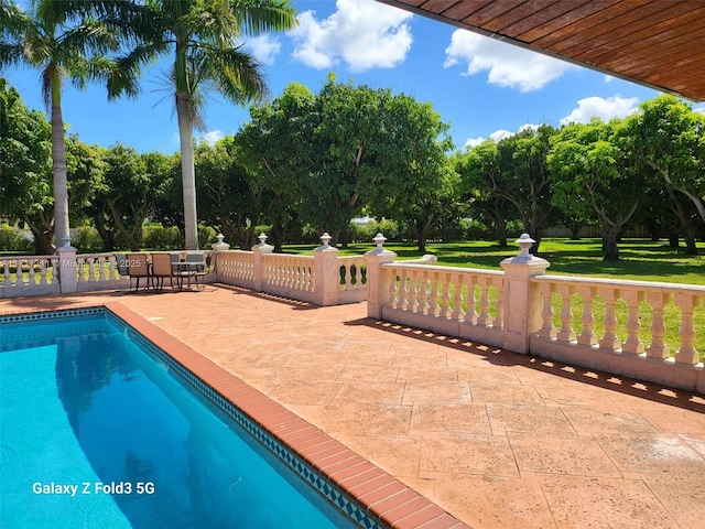 view of pool featuring a yard and a patio