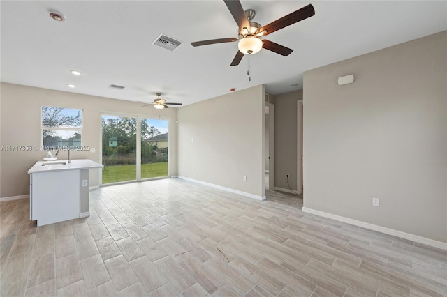 unfurnished living room with ceiling fan and light wood-type flooring