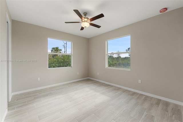 empty room featuring plenty of natural light, ceiling fan, and light wood-type flooring