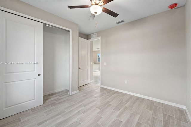 unfurnished bedroom featuring ceiling fan, a closet, and light hardwood / wood-style flooring