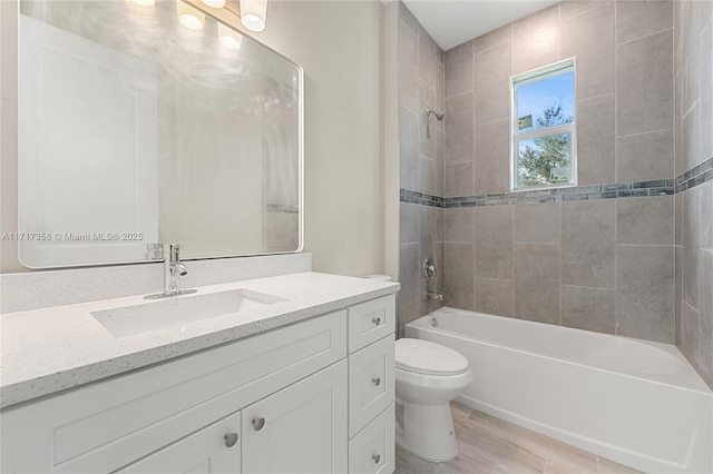 full bathroom with tiled shower / bath, vanity, toilet, and hardwood / wood-style floors