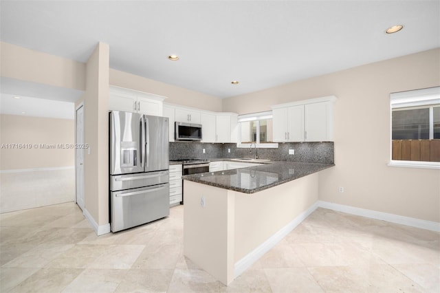 kitchen featuring kitchen peninsula, sink, white cabinets, and stainless steel appliances