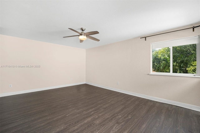 spare room with dark hardwood / wood-style floors and ceiling fan