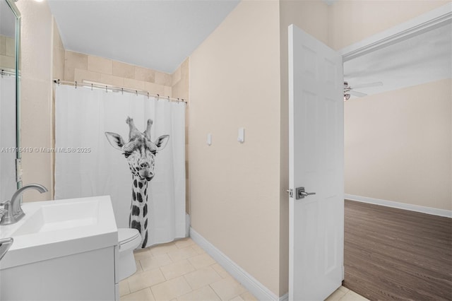 bathroom featuring a shower with shower curtain, tile patterned floors, vanity, ceiling fan, and toilet