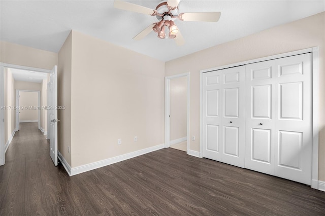 unfurnished bedroom with ceiling fan, dark hardwood / wood-style floors, and a closet