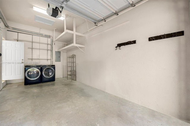 garage featuring electric panel, separate washer and dryer, and a garage door opener