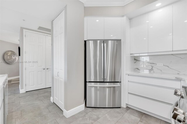 kitchen featuring kitchen peninsula, light stone counters, stainless steel appliances, sink, and white cabinetry