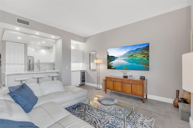 living room featuring sink, beverage cooler, and ornamental molding